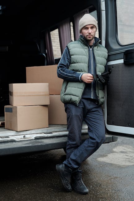 A white cargo van from Man with Van Chase Cross is parked on a residential street with a multi-storey apartment building in the background. The van is positioned parallel to the pavement, with its fro